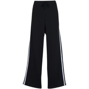 Black track pants with white stripes on the sides, featuring a drawstring waistband and a loose fit.