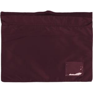 A maroon satchel with a textured surface and a small patch. It has a top opening and no visible logos.