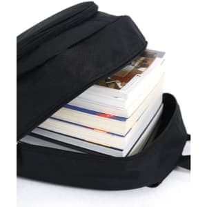 A black backpack partially open, revealing several stacked books inside. The backpack features a zip closure and a simple design.