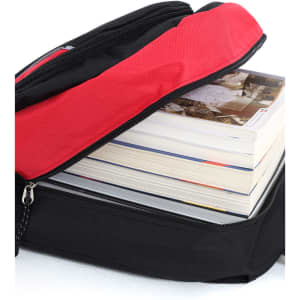 A black and red backpack with a partially opened zipper, revealing several stacked books inside.