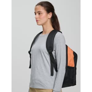 A person wearing a grey long-sleeve shirt carries a black and orange backpack with shoulder straps.