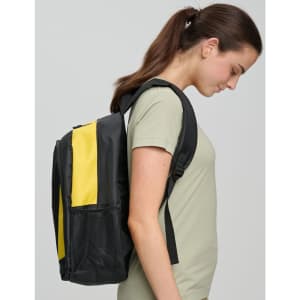 A black and yellow backpack worn by a woman, displayed from the side against a neutral background.