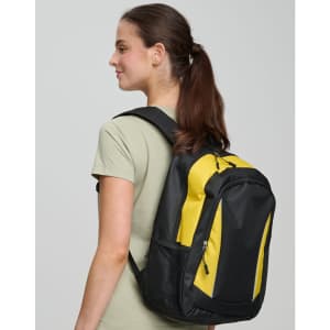 A black and yellow backpack with a logo, worn over one shoulder by a woman with long brown hair.