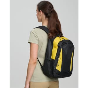A black and yellow backpack is worn on the back of a person facing away from the camera. The backpack has a logo.