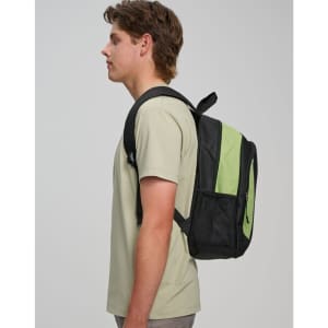 A black and green backpack worn on one shoulder by a person wearing a light-coloured t-shirt. It has a logo.