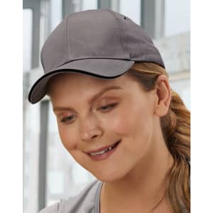A grey cap with a curved brim, featuring a logo, worn by a woman indoors.