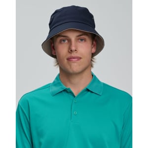 A contrasting underbrim bucket hat in navy, featuring a light-coloured underbrim, worn with a teal polo shirt.