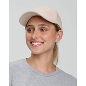 A beige Jacquard Texture 5 Panel Cap worn by a smiling individual, featuring a logo on the front.