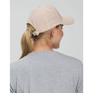 A beige Jacquard Texture 5 Panel Cap with a back ponytail opening, worn by a person with long hair.