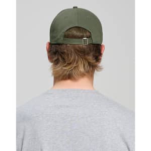 A cotton twill unstructured cap in olive green, viewed from the back, worn by a person with medium-length hair.