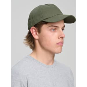 A green cotton twill unstructured cap is displayed on a person with light brown hair, wearing a grey shirt.