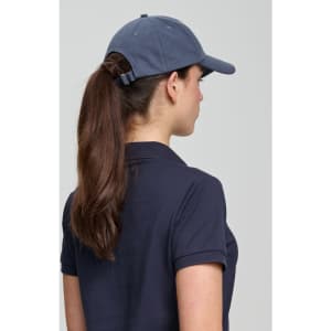 A navy cotton twill unstructured cap featuring a rear adjustment strap and worn by a person with long hair.
