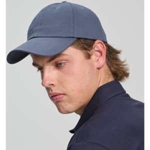 A cotton twill unstructured cap in navy blue, worn by a model with light brown hair. The cap has a logo.