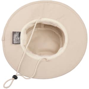 A cream-coloured brim hat with a chin strap and inner lining, featuring a logo inside.