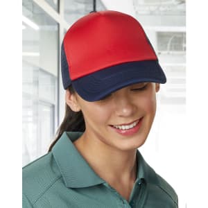 A red and navy Contrast Trucker Cap is worn by a woman with a smile, set in a bright indoor environment.