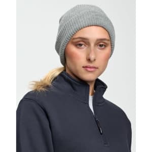 A grey knit beanie worn by a model, featuring a rolled-up cuff, alongside a dark fleece jacket.