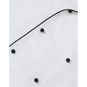 A unisex executive chef jacket in white with black buttons and piping detail. It features a classic design.