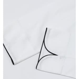 A white unisex executive chef jacket with black piping details on the cuffs. It features a clean, professional design.