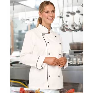 A Unisex Executive Chef Jacket in white with black accents, modelled by a smiling individual in a kitchen setting.
