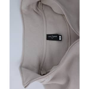 A light beige 1/2 zip collar polar fleece jumper with an inner view showcasing its soft fabric and a label.