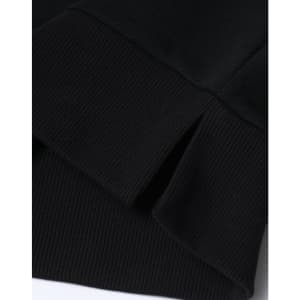 A close-up of the hem and cuff of a black unisex crew neck sweater, featuring a ribbed design and a small split detail.