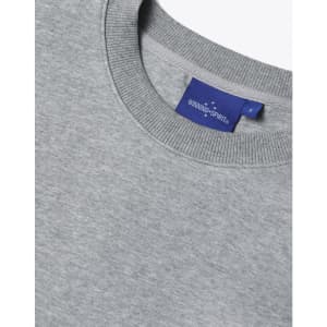 A grey unisex crew neck sweater features a ribbed neckline and a label with branding.