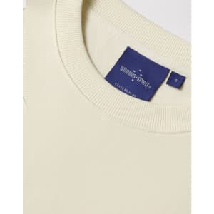 A cream unisex crew neck sweater featuring a ribbed collar and a brand tag.