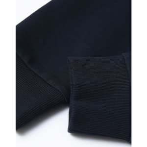 A close-up of a navy unisex crew neck sweater featuring ribbed cuffs and a smooth finish. Contains a logo.