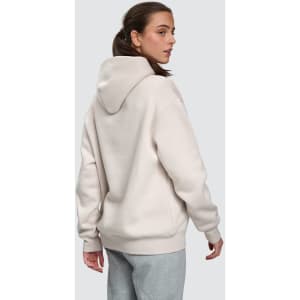 A unisex oversized hoodie in a soft cream colour, featuring a spacious hood and a relaxed fit.