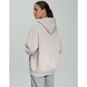 A unisex premium fleece oversized hoodie in a light beige colour, featuring a hood and a relaxed fit.