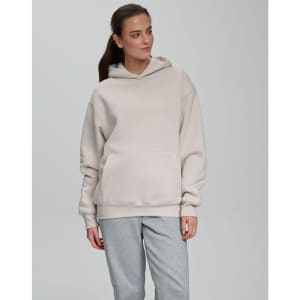 A unisex premium fleece oversized hoodie in a light beige colour with a large kangaroo pocket and a hood.