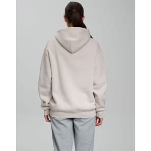 An oversized unisex hoodie in a light beige colour, featuring a spacious hood, shown from the back.