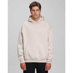 A model wearing a unisex premium fleece oversized hoodie in a light beige colour, featuring a front pocket and a hood.