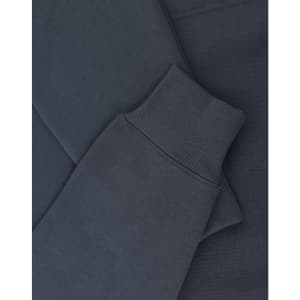 A close-up of a navy oversized hoodie featuring ribbed cuffs and soft fleece material. It includes a logo.