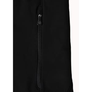 A close-up of a black softshell jacket featuring a zipped pocket and a branded logo.