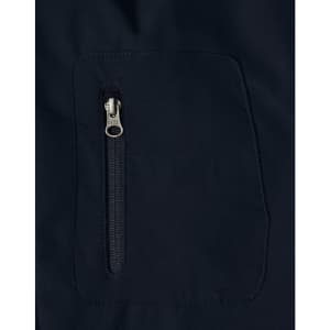 A close-up of a navy softshell jacket featuring a zippered pocket. The fabric appears smooth and durable.