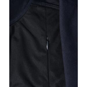 A close-up of a navy blue softshell jacket, featuring a zippered pocket and textured fabric.
