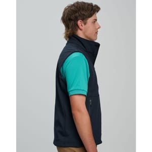 A men's navy softshell vest, featuring a zippered pocket and a branding logo, displayed on a model.