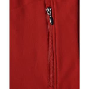 A close-up of a red softshell vest featuring a zippered pocket and a logo.