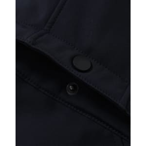 A close-up of a navy softshell jacket featuring a snap button and interior stitching details.