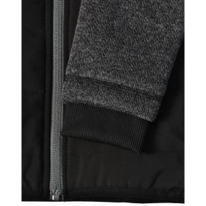 A black quilted body jacket with a heather grey sleeve and ribbed cuffs, featuring a zip closure.