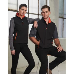 A black softshell contrast vest with orange and grey detailing, worn by two models. The vest features a zip and pockets.
