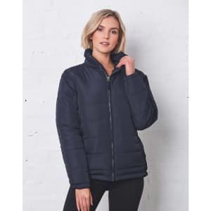 A navy heavy quilted puffer jacket with a zip and high collar, featuring a woman posing against a white brick wall.