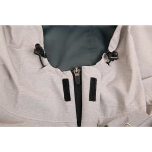 A close-up of a light grey waterproof performance jacket, featuring adjustable toggles and zip fastening.