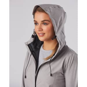 A grey waterproof performance jacket featured on a model, showcasing a hood and drawstring detail.