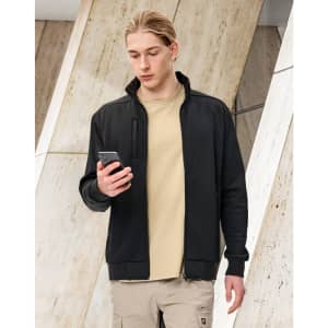 A man in a black fleece jacket holding a smartphone, set against a modern architectural background.