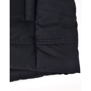 A close-up of a black seamless parka jacket, featuring a textured fabric and contrasting stitching details.