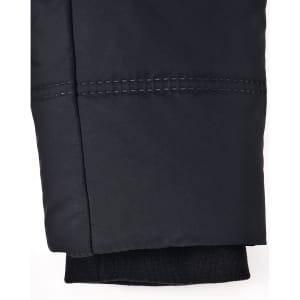 A close-up of a black seamless parka jacket sleeve, featuring stitching details and a knitted cuff.