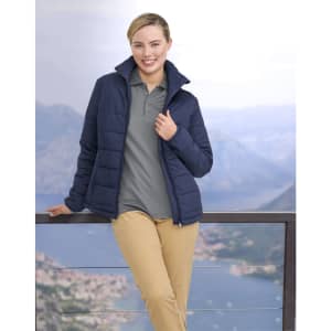 A navy blue insulated puffer jacket with a 3D cut, worn by a woman against a scenic outdoor backdrop.