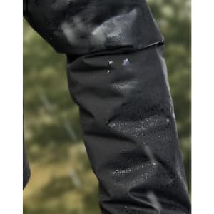 A close-up of a black waterproof jacket sleeve with droplets of water beading on the surface.